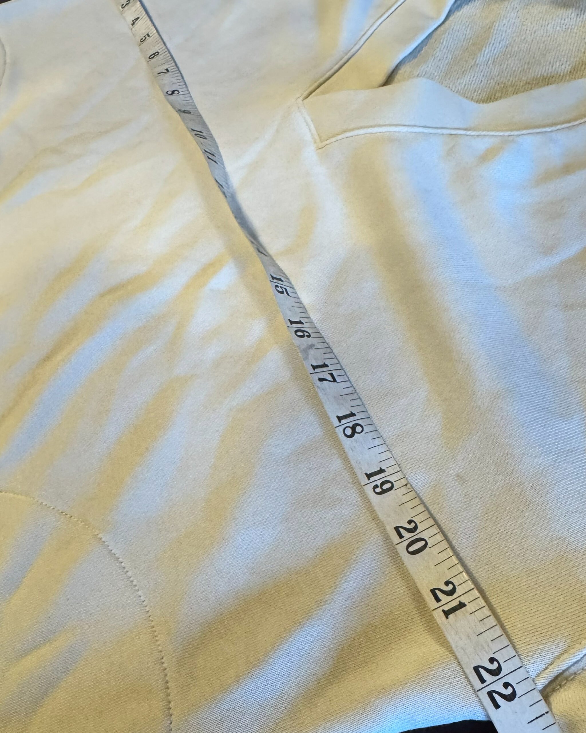Flexible measuring tape placed across a garment to show the pit-to-pit measurement