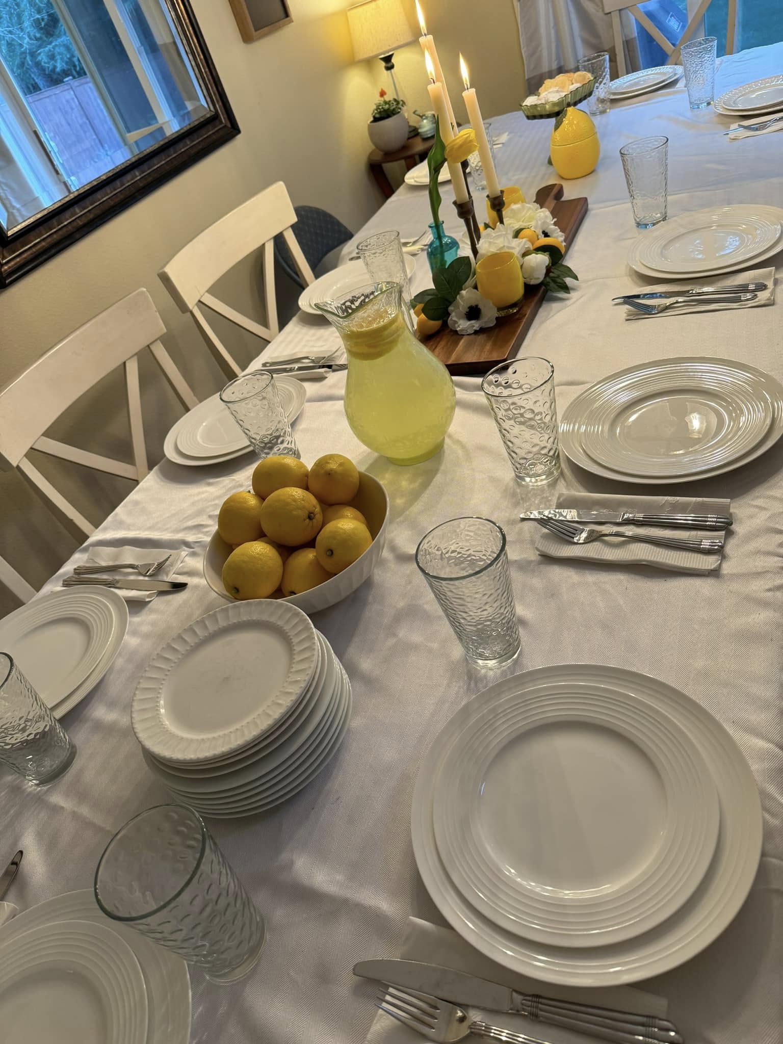 Fresh lemons and greenery arranged on a white dinner table