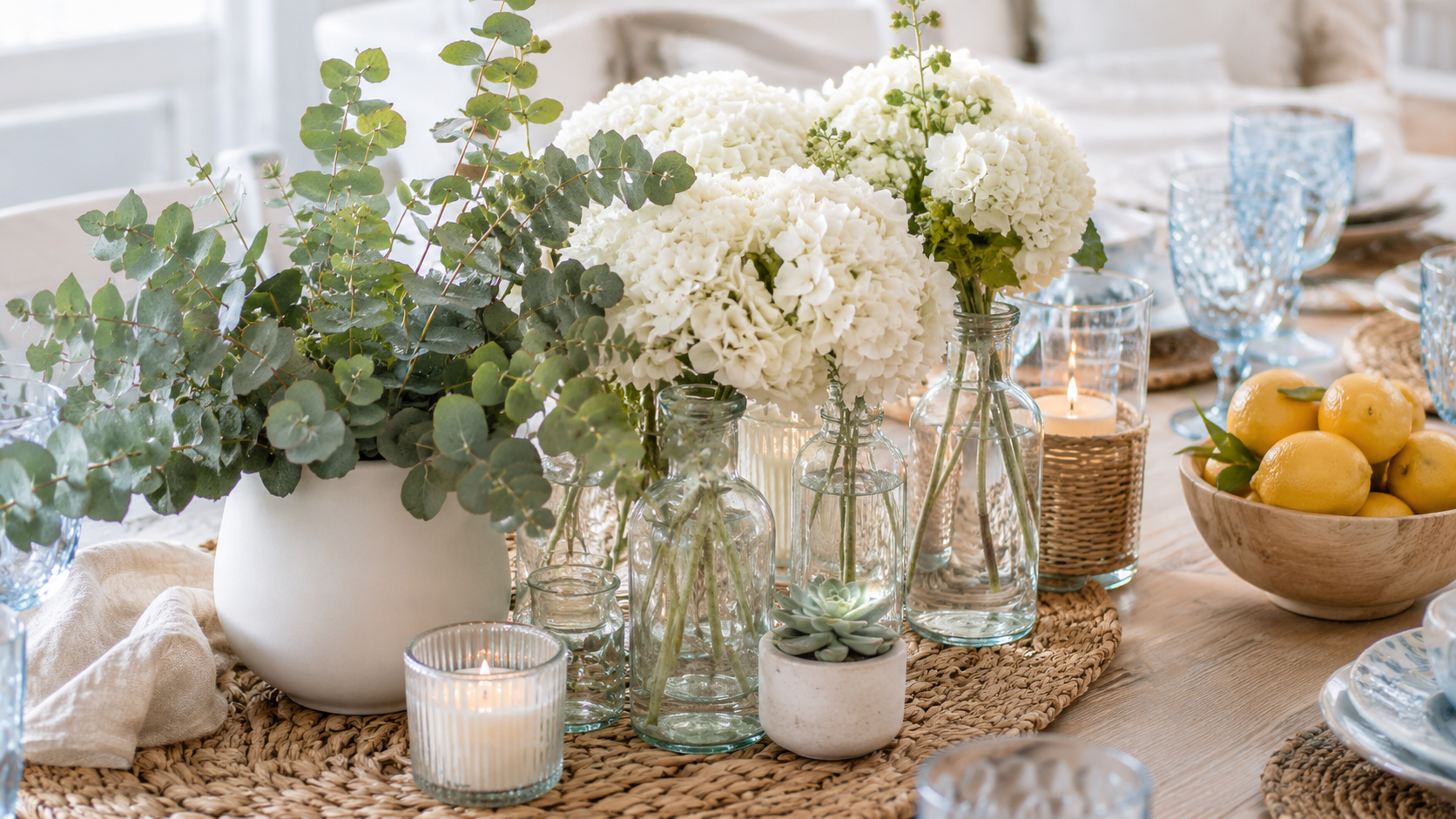 Coastal table with white hydrangeas eucalyptus blue glassware and lemons